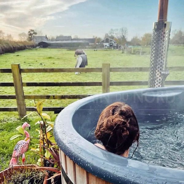 une personne est dans son bain nordique hot tub et qui regarde des chevaux